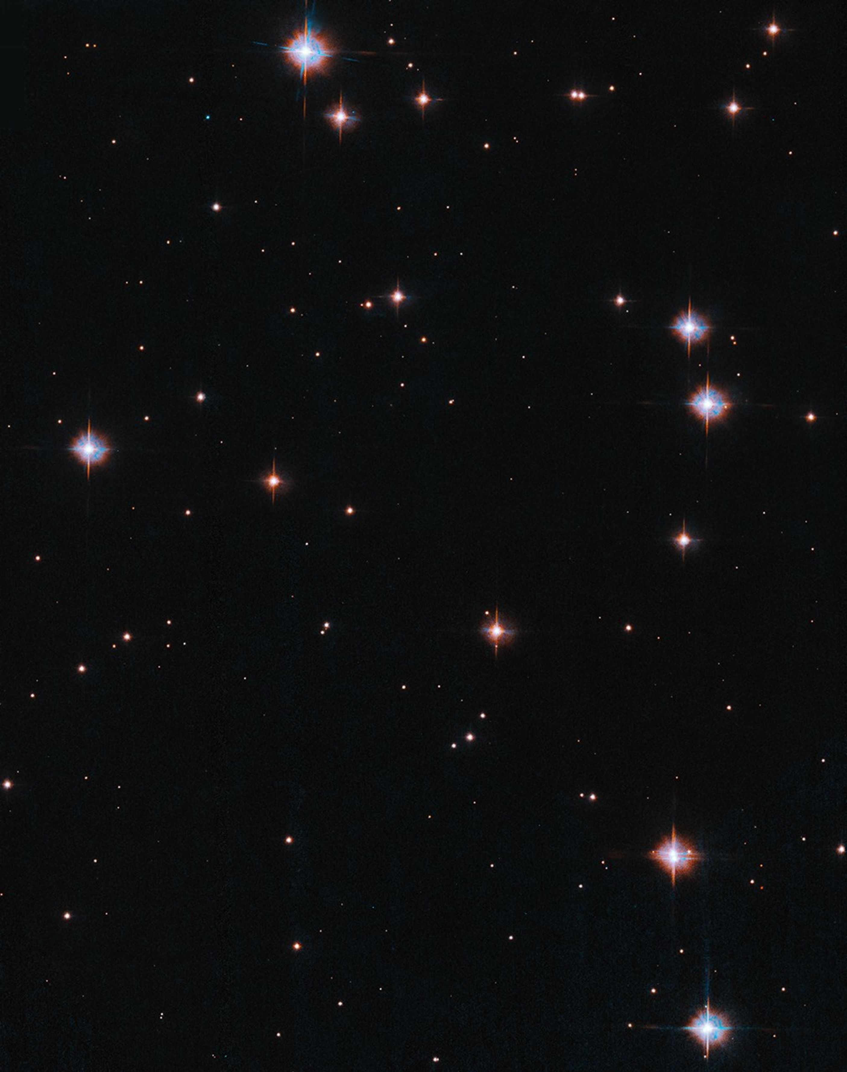 Scattered white-colored stars shine against an inky black background.