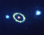 Dark blue background. near image center is a pink blob surrounded by a yellow ring. On either side of the ring are blue-white blobs.