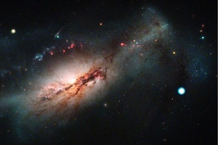 The galaxy NGC 2146 with a bright-white object (SN 2018zd)