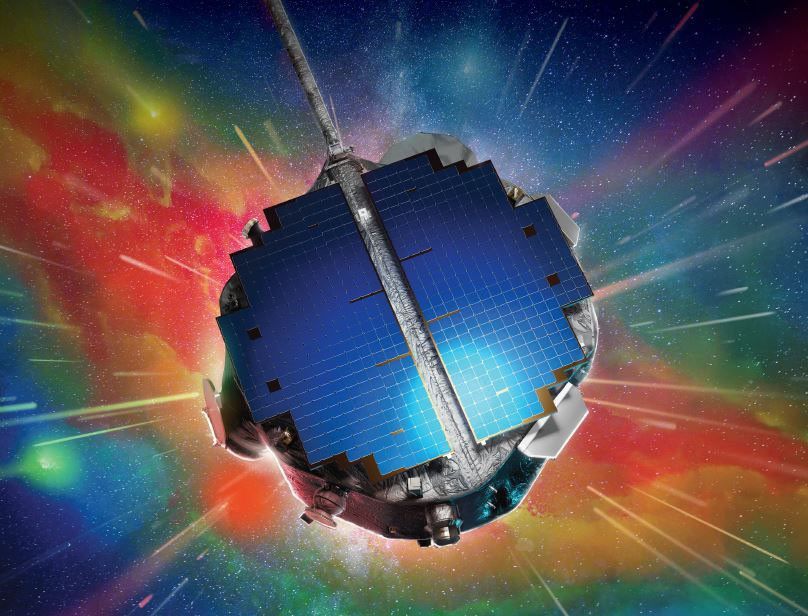 Spacecraft with blue solar panels sitting in front of a rainbow of colors in space.