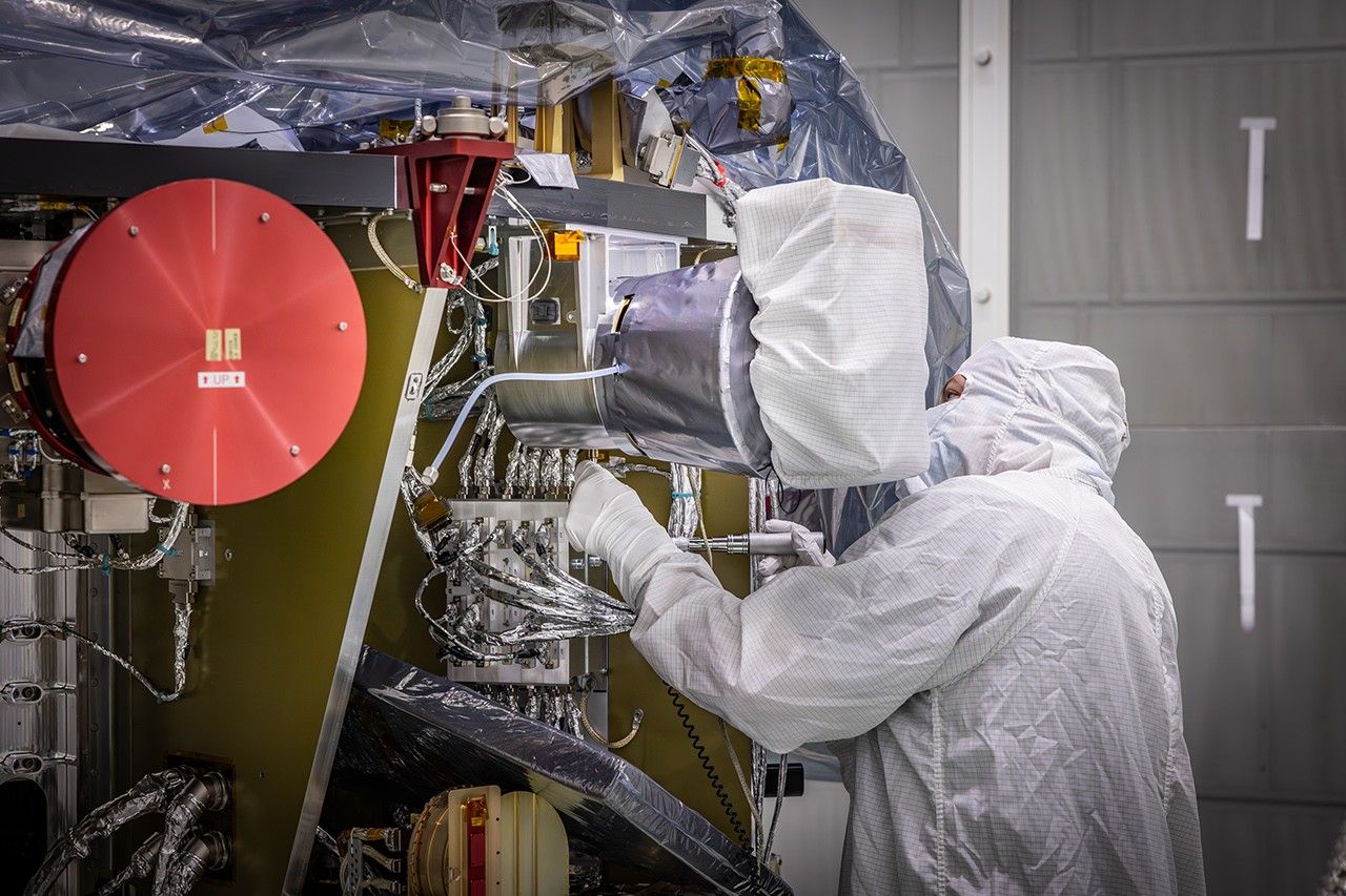 Image shows technician in a white bunny suit reintegrate the Solar Wind and Pickup Ions (SWAPI) instrument of NASA’s IMAP (Interstellar Mapping and Acceleration Probe) observatory inside the high bay at the Astrotech Space Operations Facility near the agency’s Kennedy Space Center in Florida on Monday, June 23, 2025.
