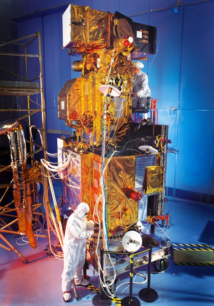 Landsat 7 spacecraft modules undergoing final integration and testing in a cleanroom facility prior to launch.