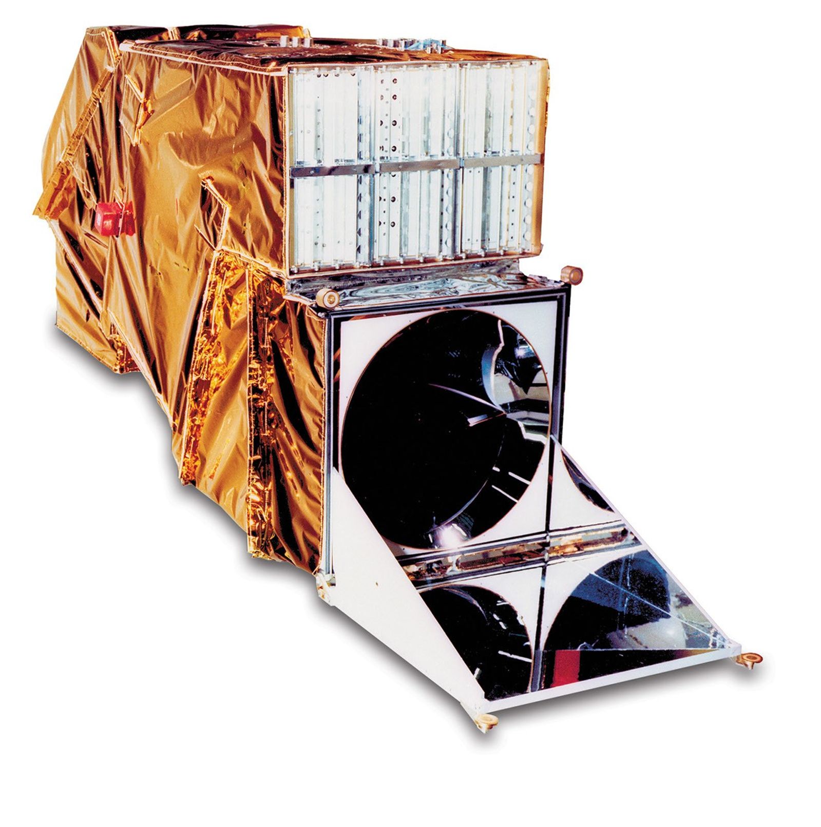 Side view of the Thematic Mapper instrument model displaying the gold thermal protection, exposed detector arrays, and scanning mirror mechanism used for capturing multispectral Earth imagery.