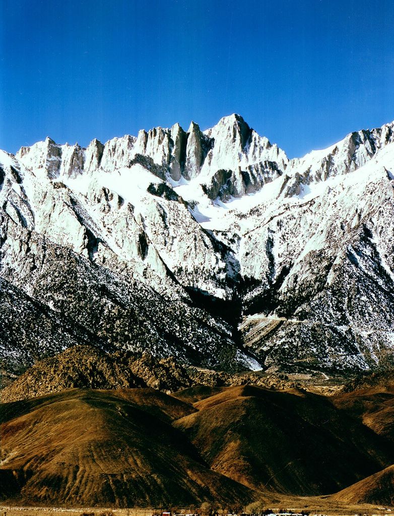 Landsat 5 Thematic Mapper image of Mount Whitney in the Sierra Nevada, showing the dramatic granite peaks and ridges with snow-covered summits rising above desert foothills.