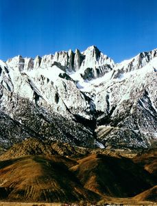 Landsat 5 Thematic Mapper image of Mount Whitney in the Sierra Nevada, showing the dramatic granite peaks and ridges with snow-covered summits rising above desert foothills.