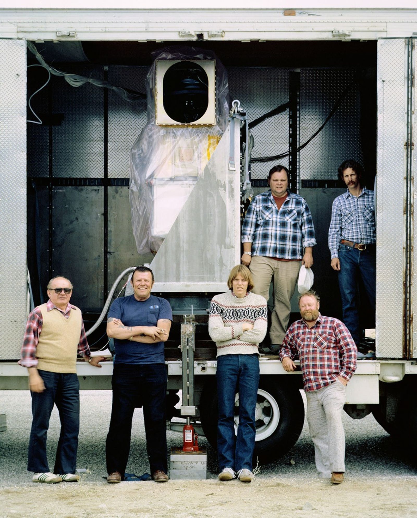 Team members posing with Landsat 5 TM receiving equipment housed in mobile trailer during field operations.