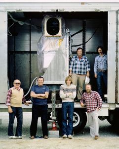 Team members posing with Landsat 5 TM receiving equipment housed in mobile trailer during field operations.