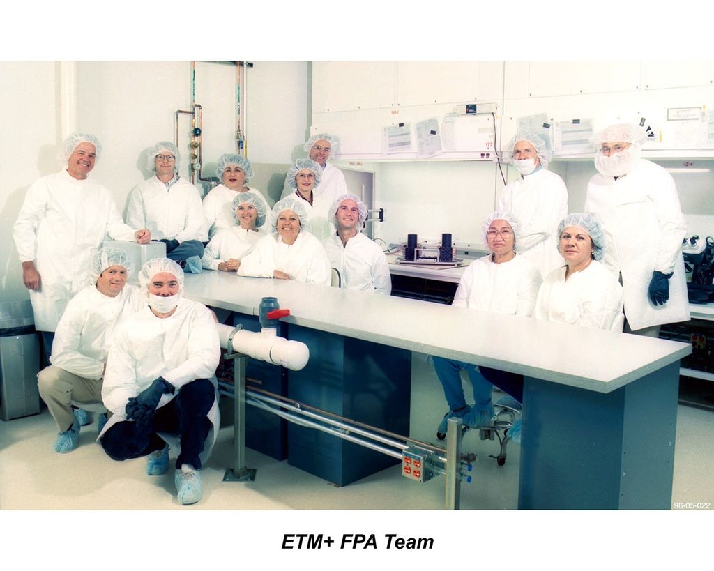 The Engineering team responsible for developing the Focal Plane Assembly (FPA) for Landsat 7's Enhanced Thematic Mapper Plus instrument, photographed in their cleanroom facility.