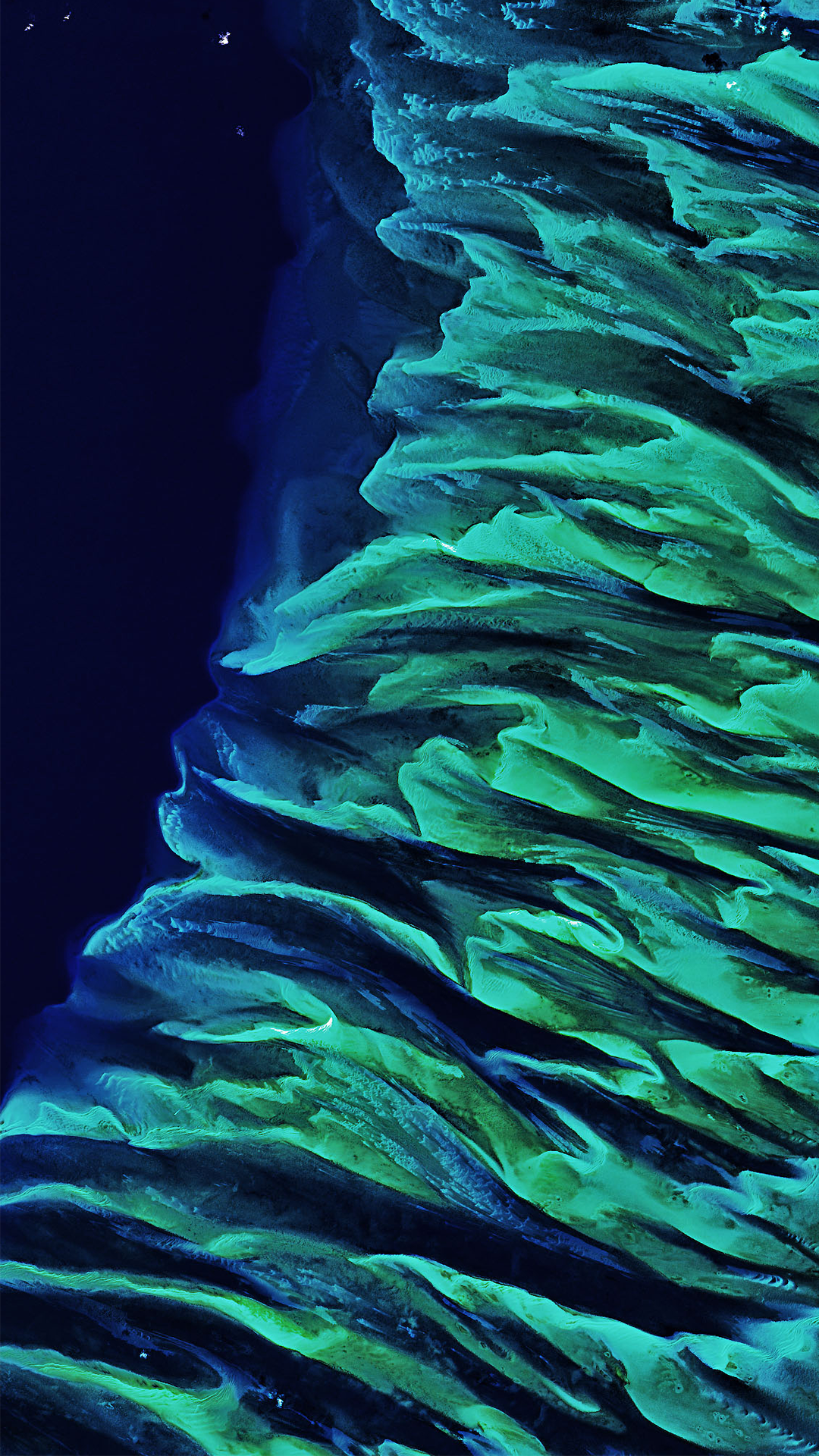 A Landsat satellite image featuring stark light green and blue shallow water and sands in the Great Bahama Bank