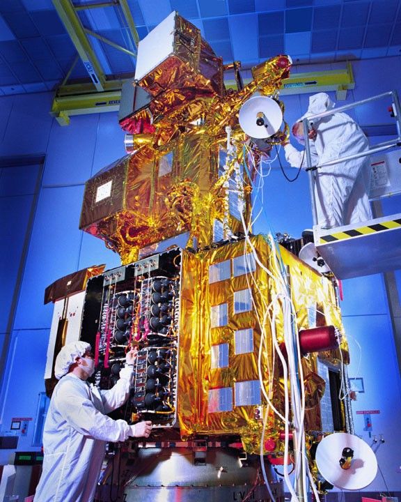 Landsat 7 Earth observation satellite undergoing final integration and testing in a controlled cleanroom environment prior to its April 1999 launch.