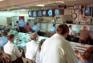 Historical spacecraft launch control room with mission personnel monitoring consoles and displays during operations.