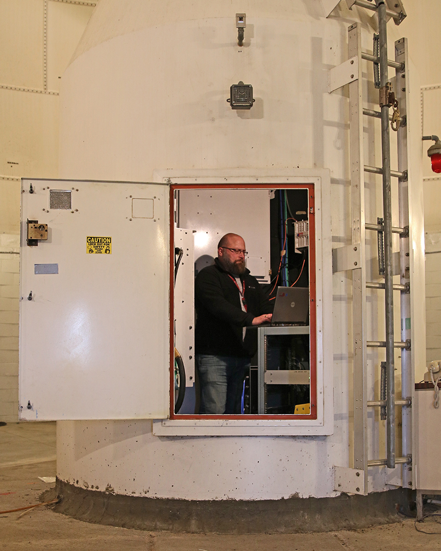 Within the large Radome at the U.S. Geological Survey�s Earth Resource Observation & Science Center, Aaron Hensley, a ground station technician, stands inside the pedestal of the 10-meter antenna to inspect communication components. The 10-meter antenna is the primary antenna for Landsat 7 and Landsat 8 communications in Sioux Falls, South Dakota.