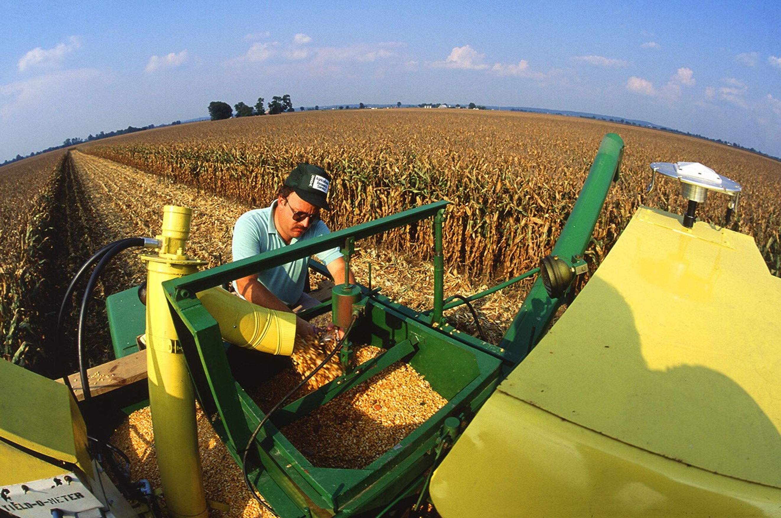 Agricultural engineer Kenneth Sudduth examines a sample of grain collected from this combine's grain flow sensor.