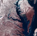 A false-color Landsat 8 and 9 mosaic of the partially frozen Chesapeake Bay region in February 2026.. In the image, healthy vegetation appears red, snow appears white, ice appears light blue, water appears dark blue, and bare earth appears tan.