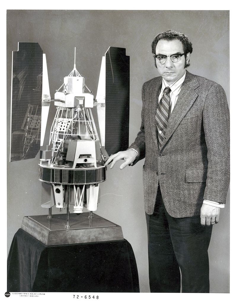A photograph of NASA scientist Stan Freden with a Landsat 1 model.
