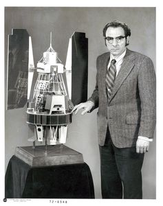 A photograph of NASA scientist Stan Freden with a Landsat 1 model.