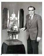 A photograph of NASA scientist Stan Freden with a Landsat 1 model.