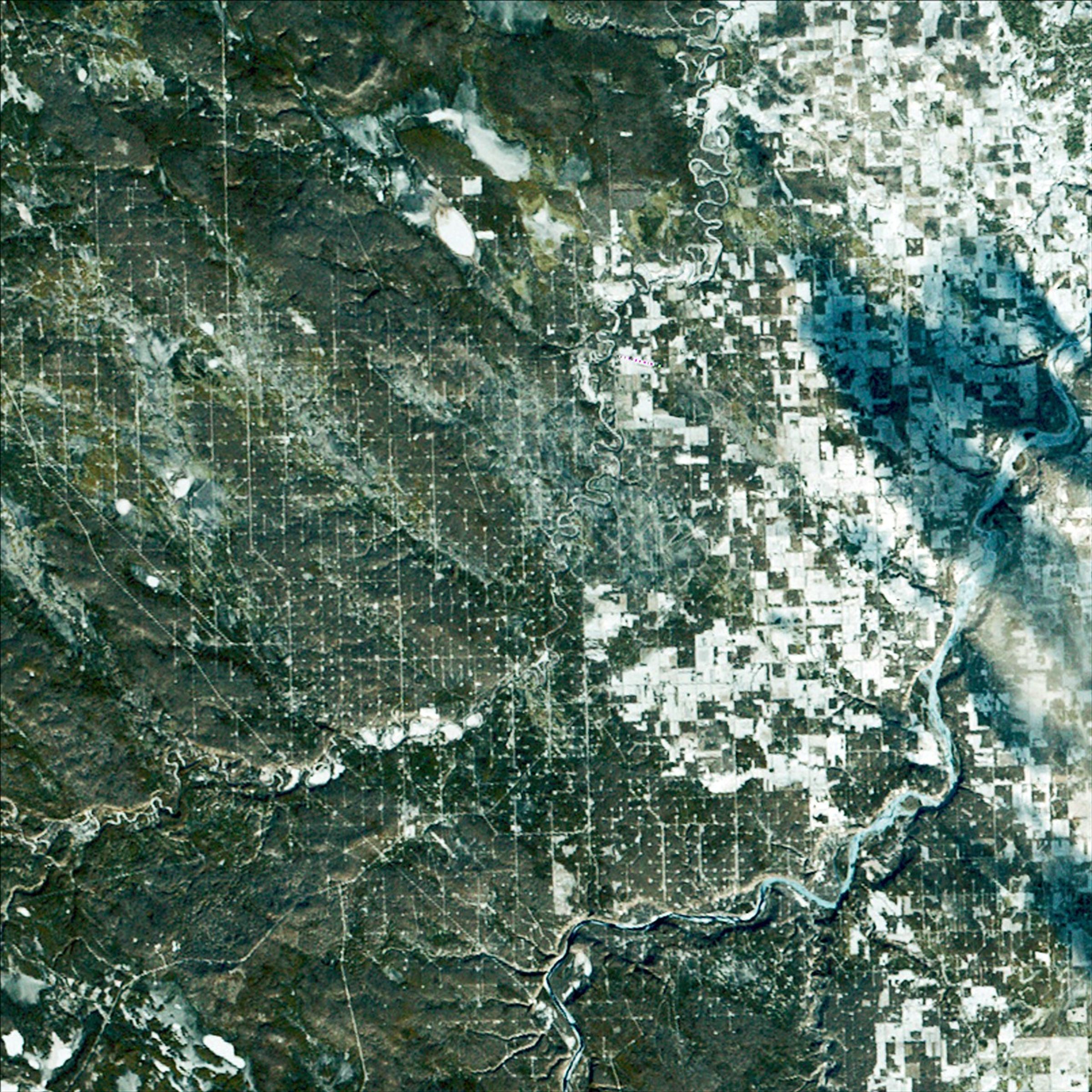 Landsat 2’s first light image captured Drayton Valley in Alberta, Canada on January 24, 1975. Located along Canadian Highway 22, also known as Cowboy Trail, the town’s original economy thrived on faming and logging. The discovery of the Pembina oil field in 1953 contributed to explosive growth in the sparsely populated area, with an increase from 75 individuals to 2,000.