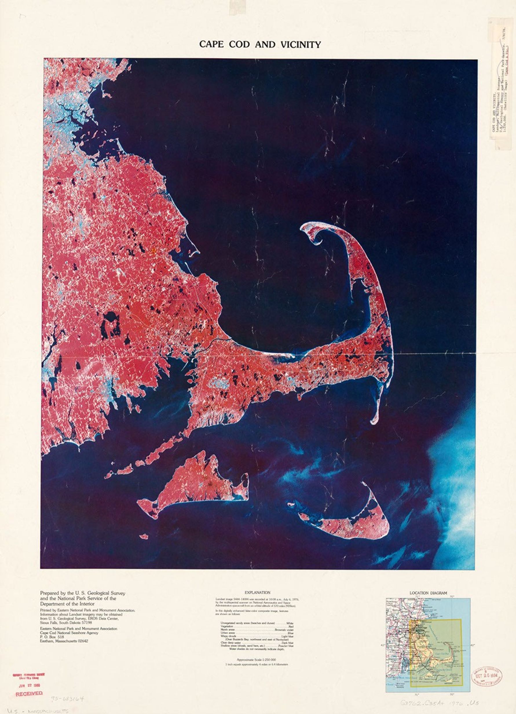 A digitally enhanced false-color satellite image of Cape Cod and vicinity, showing the distinctive curved peninsula extending into the Atlantic Ocean. The landmass appears in reddish tones while water is dark blue. The image clearly shows Cape Cod's hook shape, along with Martha's Vineyard and Nantucket islands to the south. A location map and explanatory text appear below the main image.
