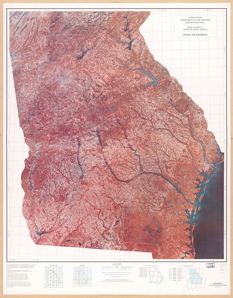 A false-color satellite image mosaic of the entire state of Georgia, created from LANDSAT-1 data collected in 1973-74. The state appears in reddish-pink tones with blue waterways, including major rivers and the Atlantic coastline visible on the right side. The image clearly shows the state's geographic features, from the Appalachian mountains in the north to the coastal plains in the south.