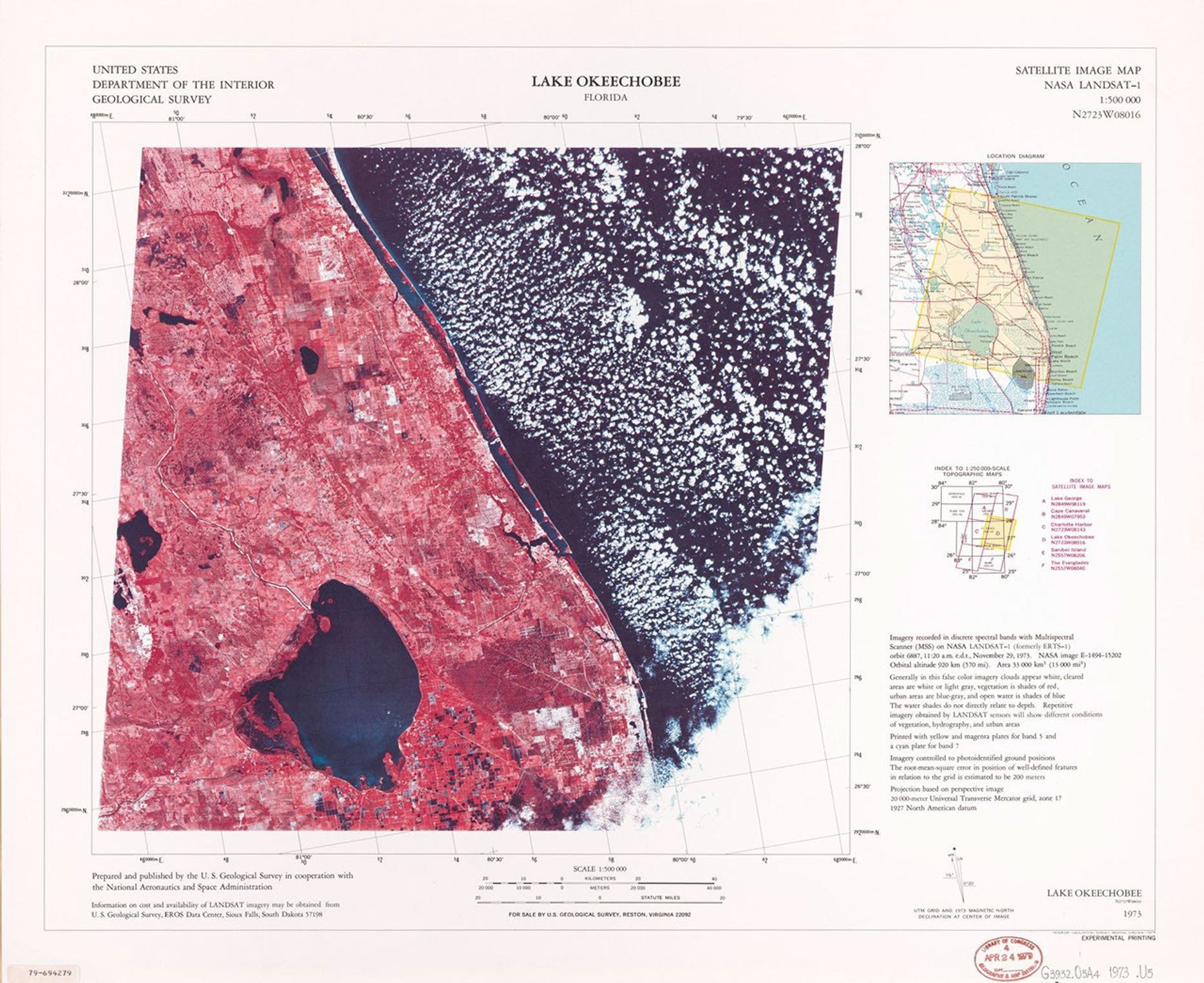 A false-color satellite image map of Lake Okeechobee, Florida, from 1973, produced using NASA LANDSAT-1 data. The large circular lake appears as a dark blue body in the lower left portion of the image, surrounded by reddish-pink agricultural and developed areas. The Atlantic coast is visible along the right side. The map includes coordinate grids, a location diagram, and explanatory text in the margins.