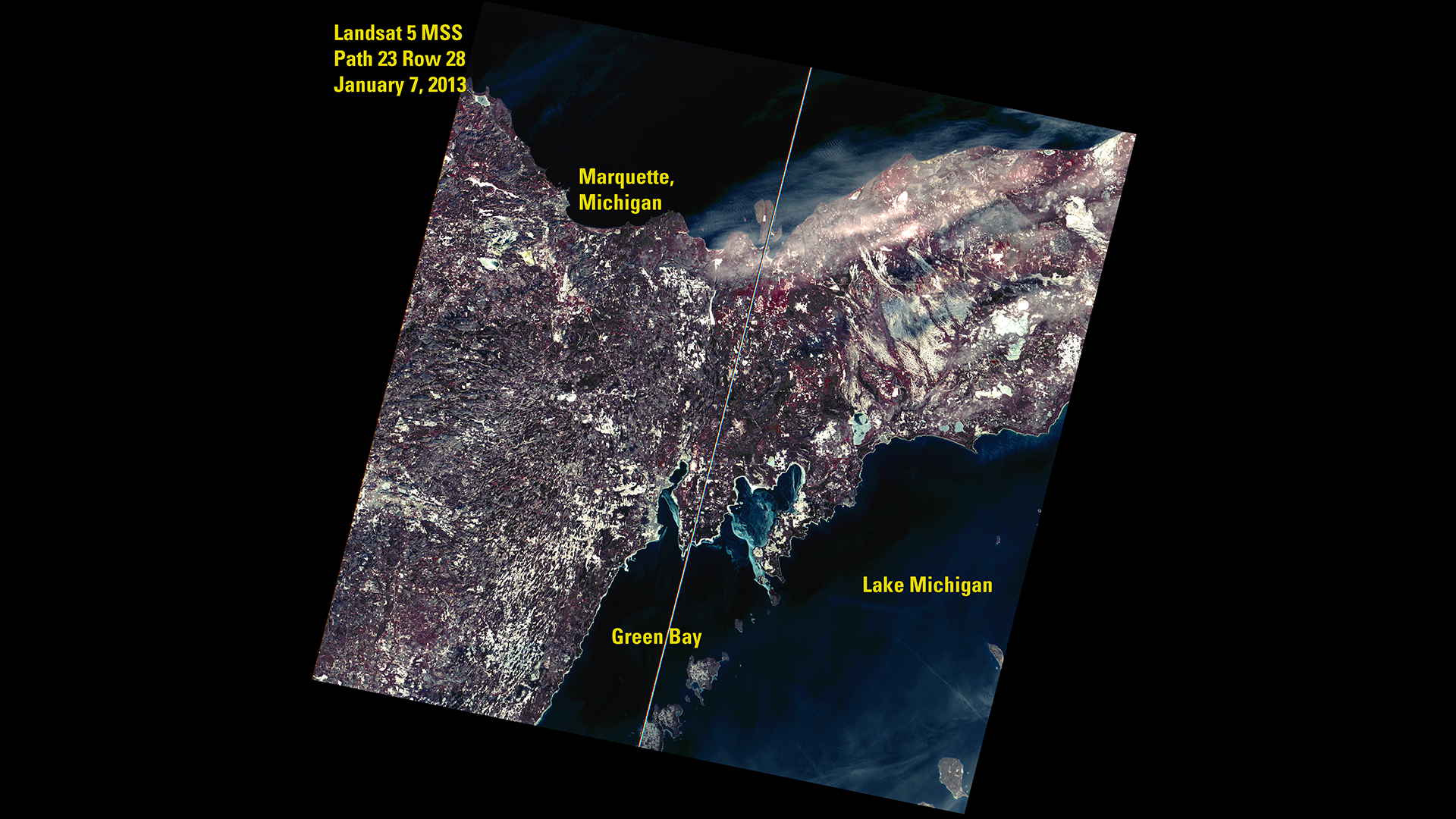 A Landsat 5 satellite image of Lake Michigan. Text on this image reads as Landsat 5 MSS, Path 23 Ros 28, January 7, 2013. Text also highlights  Marquette, Michigan, Lake Michigan, and Green Bay