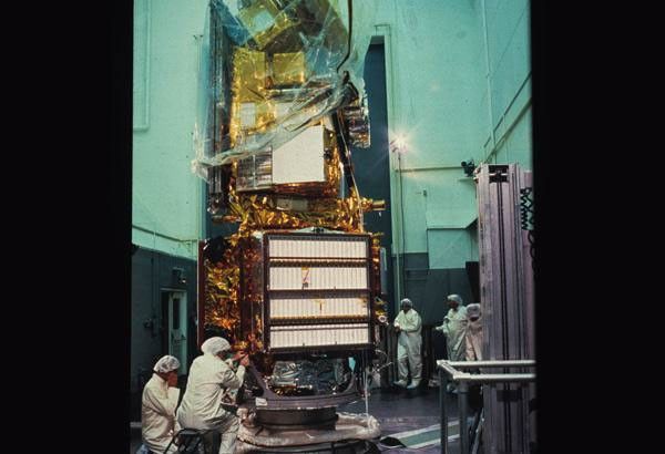 A photograph of Landsat 5 in a clean room being worked on.