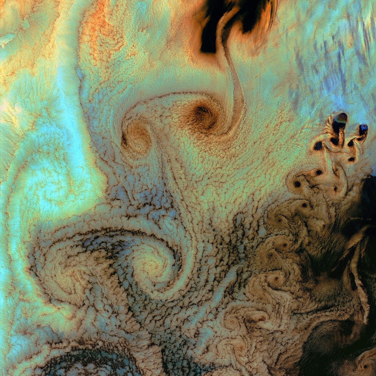 July 4th, 2002: Description: As air flows over and around objects in its path, spiraling eddies, known as Von Karman vortices, may form. The vortices in this image were created when prevailing winds sweeping east across the northern Pacific Ocean encountered Alaska’s Aleutian Islands.