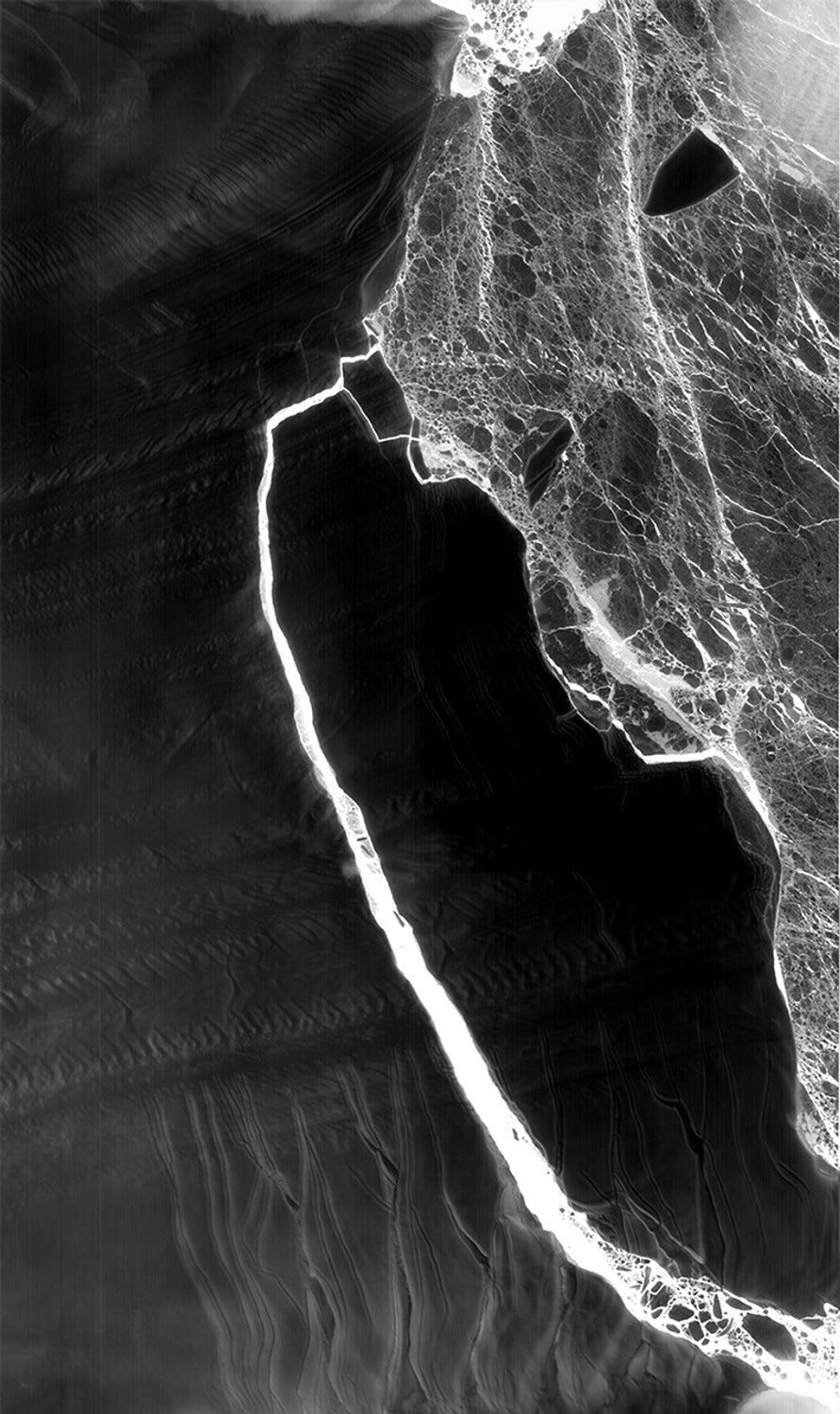 As Antarctica remains shrouded in darkness during the Southern Hemisphere winter, the Thermal Infrared Sensor (TIRS) on Landsat 8 captured a new snap of the 2,240-square-mile iceberg that split off from the Antarctic Peninsula’s Larsen C ice shelf on July 10-12. The satellite imagery is a composite of Landsat 8 as it past on July 14 and July 21 and shows that the main berg, A-68, has already lost several smaller pieces. The A-68 iceberg is being carried by currents northward out of its embayment on the Larsen C ice shelf. The latest imagery also details a group of three small, not yet released icebergs at the north end of the embayment.