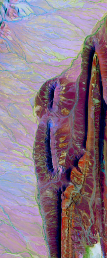 Landsat satellite image of land folds in the desert in Morocco form the lower case letter I.