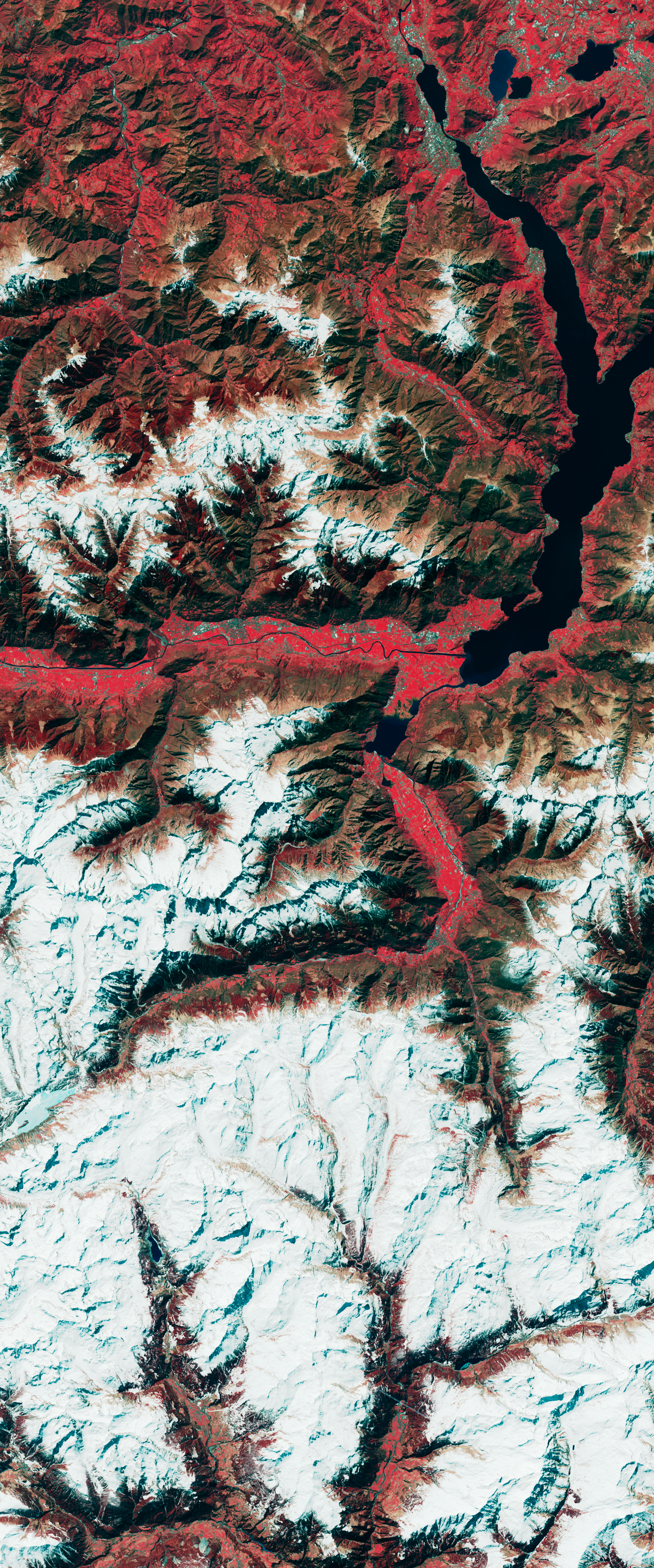 False-color Landsat satellite image showing bare land among forested slopes forming the number 3.