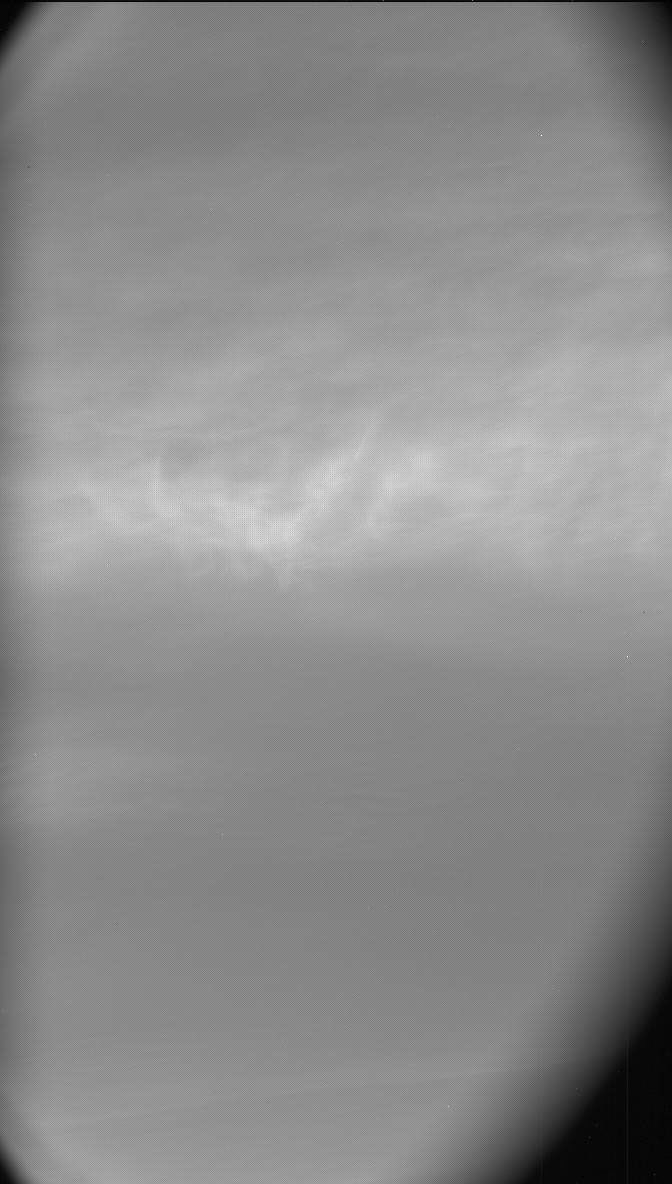 A grayscale oval image inside a rectangular frame shows a hazy, medium gray sky, with a band of illuminated, wispy, whitish-gray clouds spanning the center of the image from left to right.