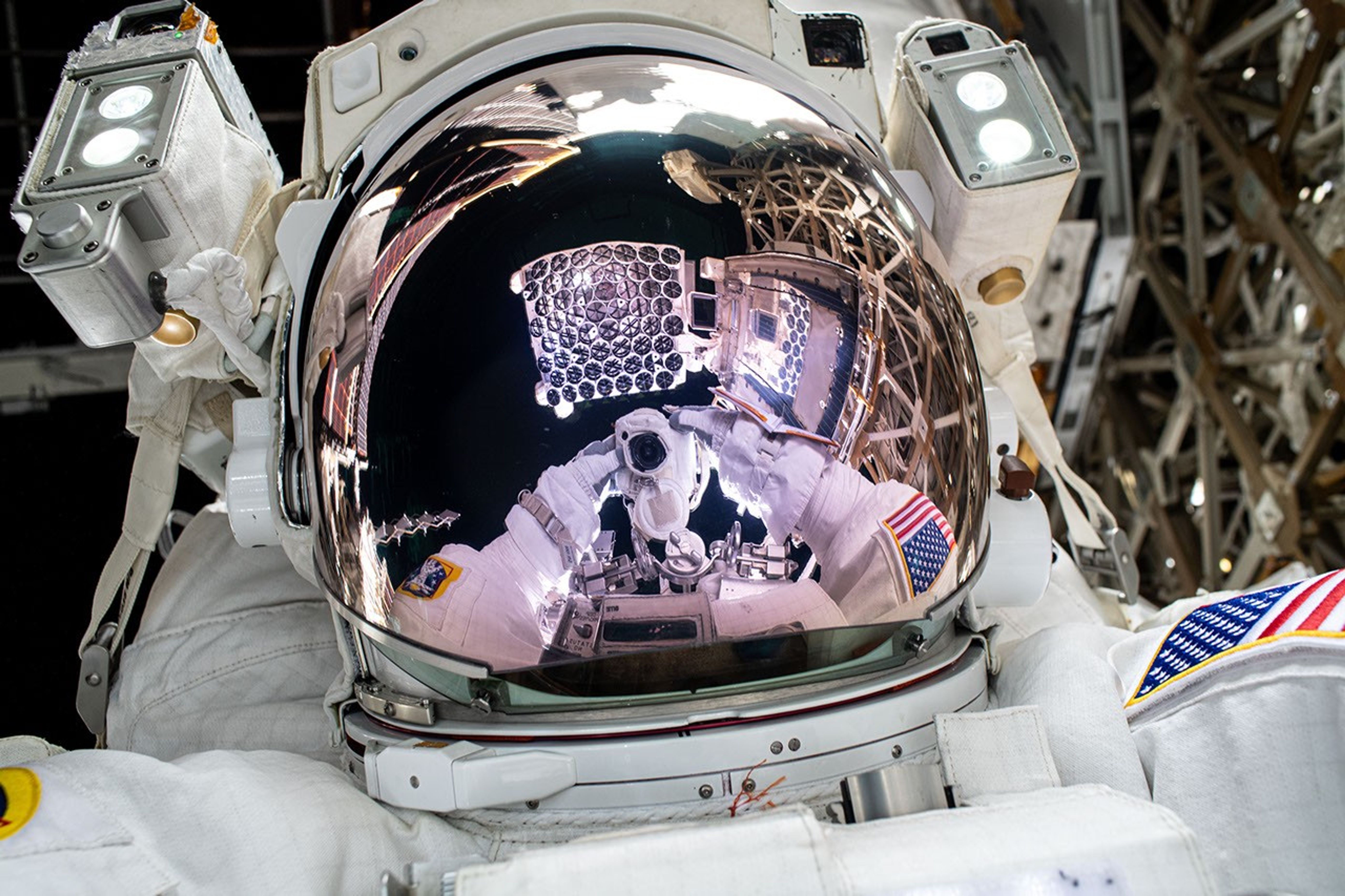 An astronaut takes a selfie with a telescope