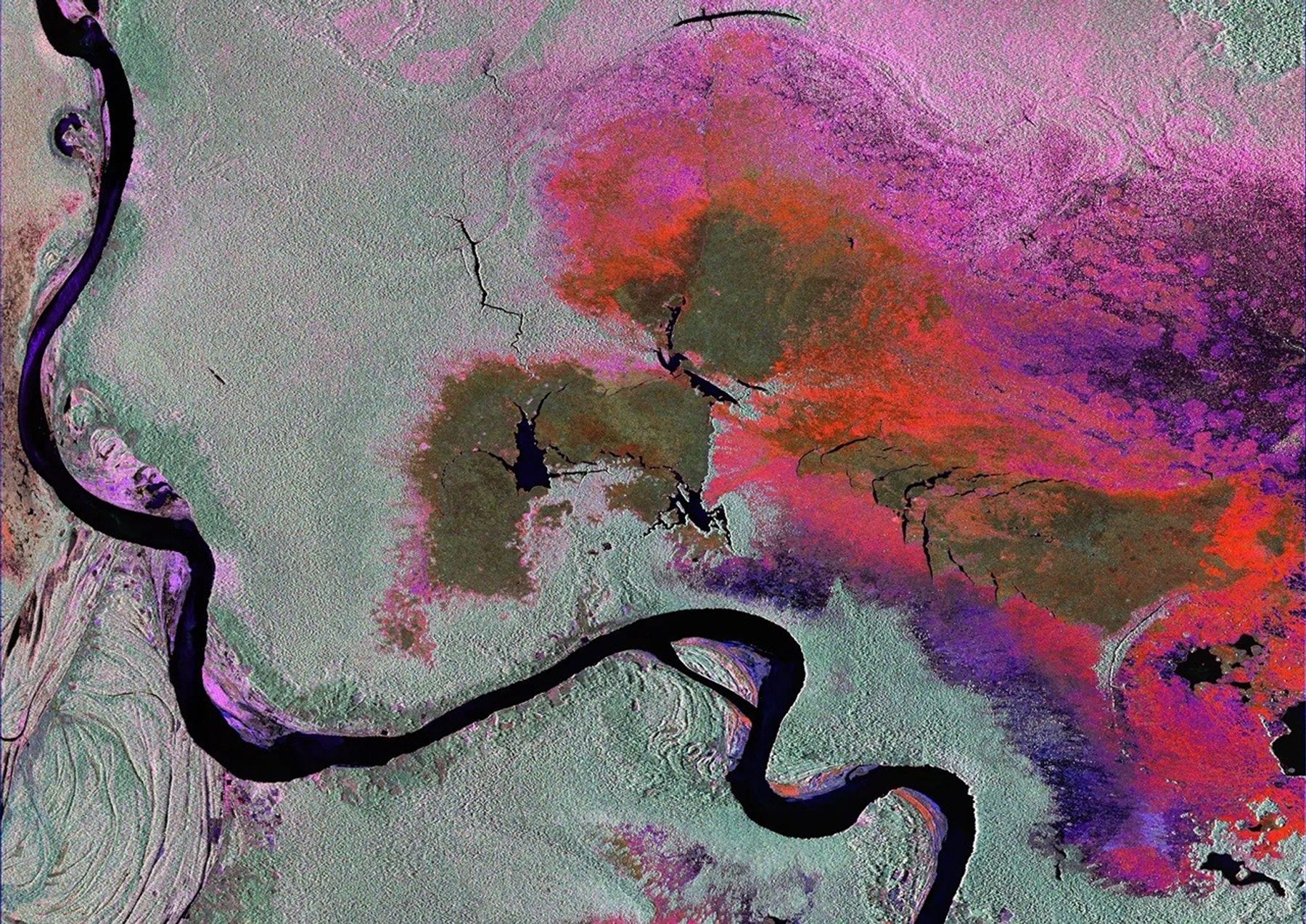a highly colorful field, from blues, purples, reds and browns, reside on a mostly sage green landscape with a black river meander running from upper left to lower right of center.