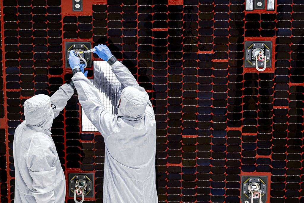 A close-up of technicians working on a Roman solar panel