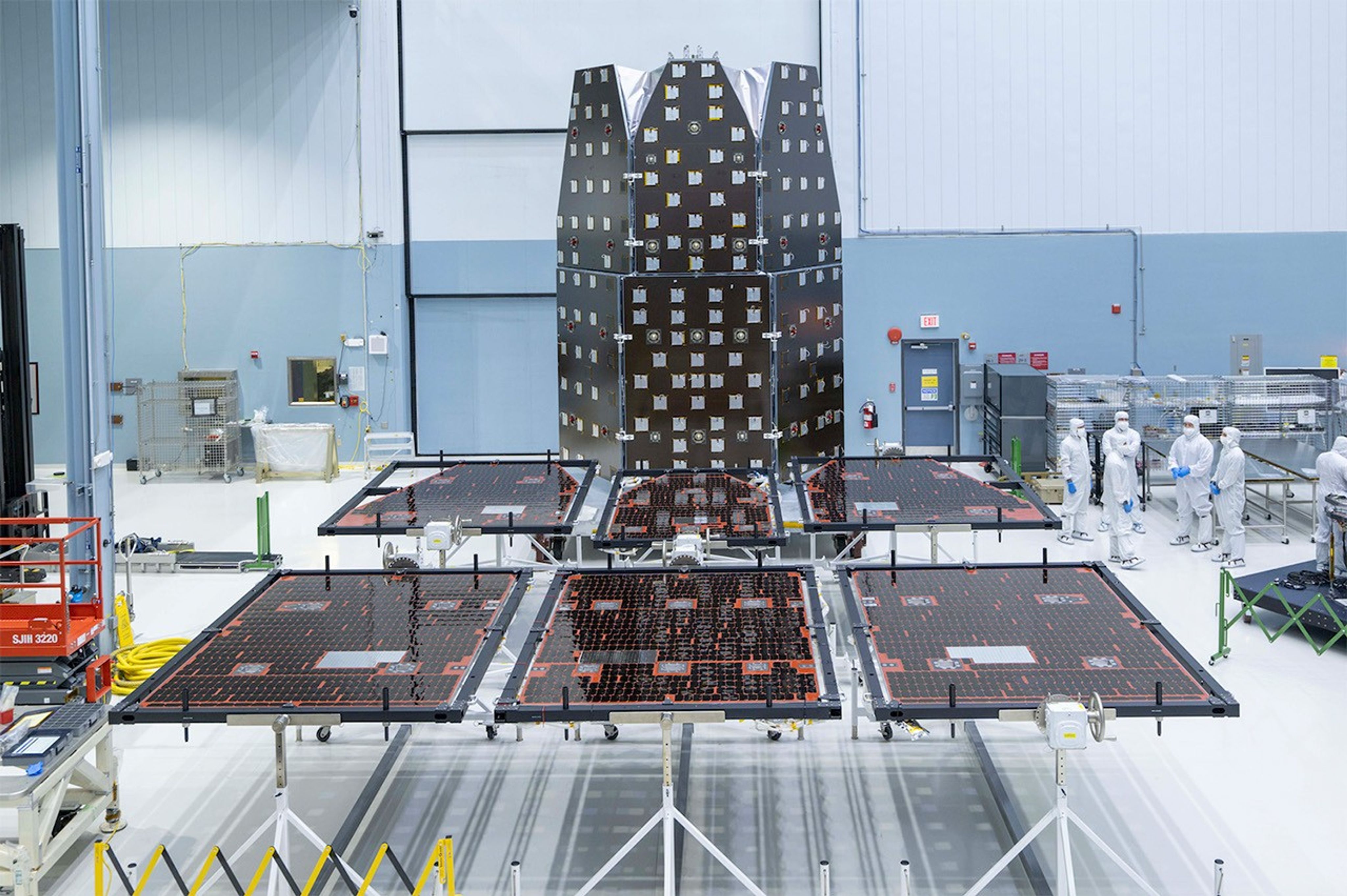 Both versions of the Solar Array Sun Shield for NASA’s Nancy Grace Roman Space Telescope appear in this photo, taken in the largest clean room at NASA’s Goddard Space Flight Center. The flight version lies flat in the foreground, while the qualification assembly stands upright in the background. The flight panels will shade the mission’s instruments and power the observatory.