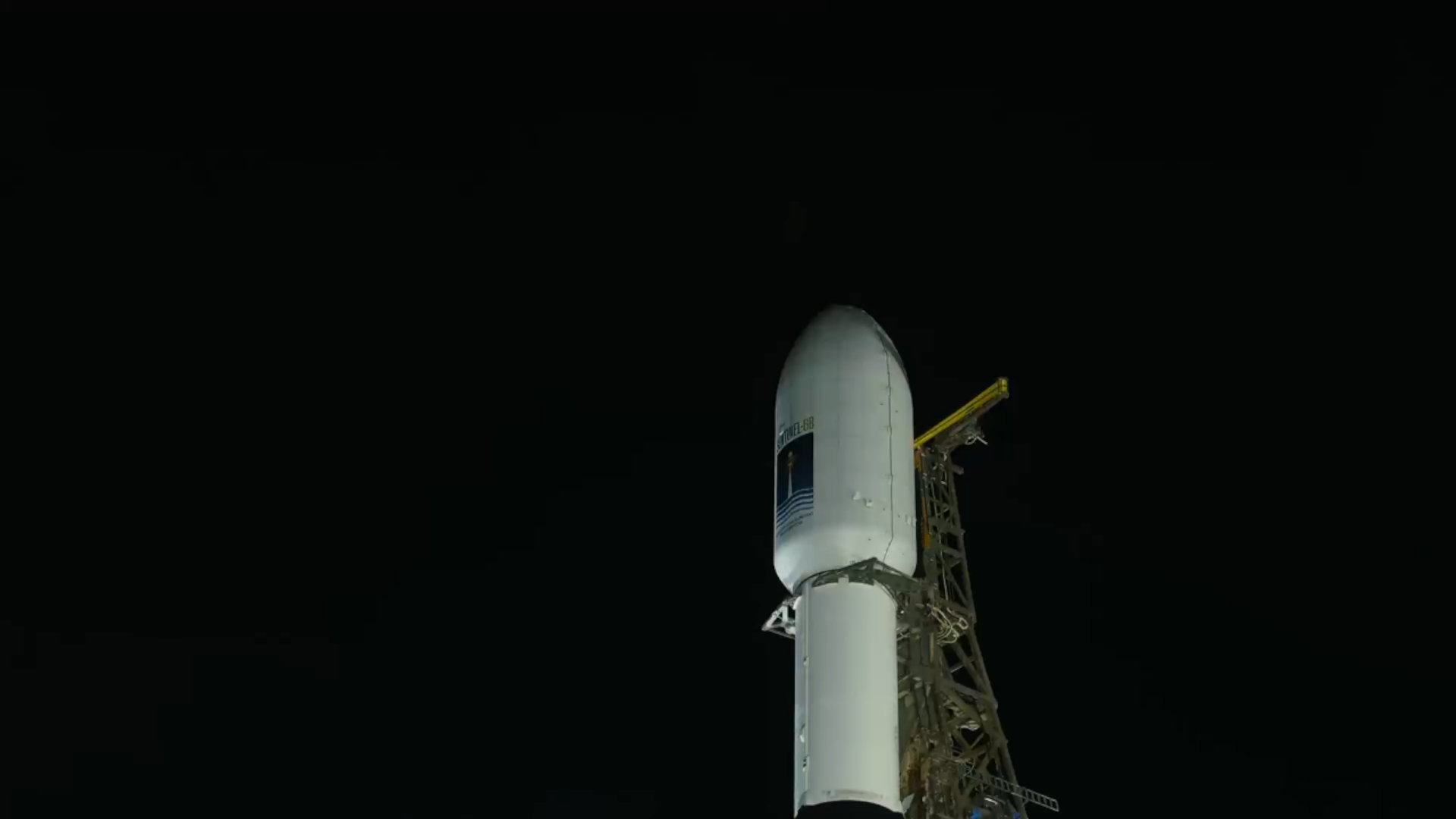 Image shows night time with a closeup view with a white payload fairing with NASA's Sentinel-6 Satellite inside.