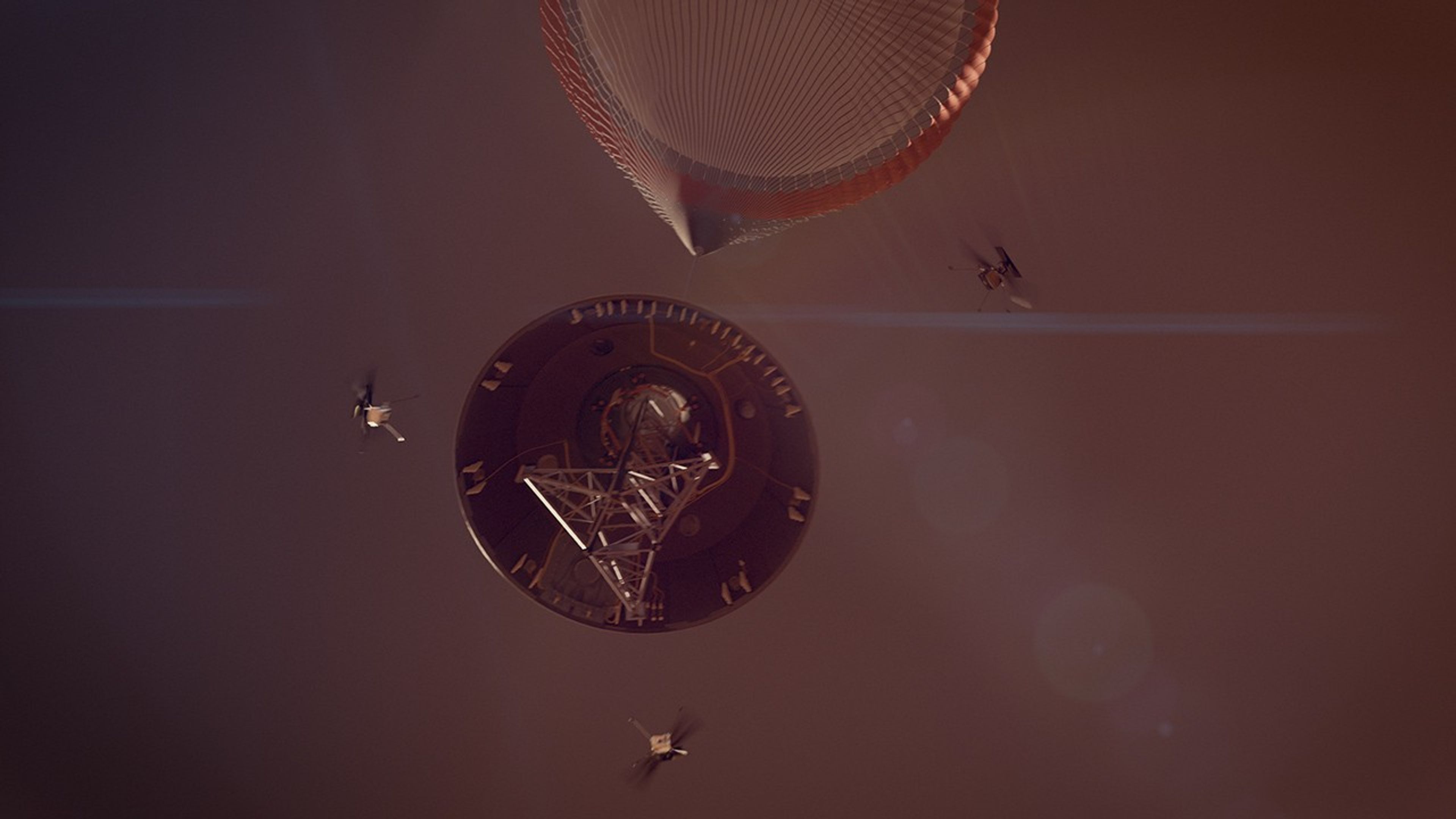 Artist's concept of a spacecraft descending through a dark, reddish-brown Martian atmosphere. At the top, a large, fully deployed parachute suspends a circular entry vehicle or backshell viewed from below. The interior of the backshell reveals complex mechanical components and a central truss structure. Surrounding the descending spacecraft, three small SkyFall robotic helicopters are shown in mid-flight with their blades spinning rapidly, having just deployed and dispersed to the left, bottom, and upper right. A prominent, thin horizontal blue lens flare streaks across the center of the scene.