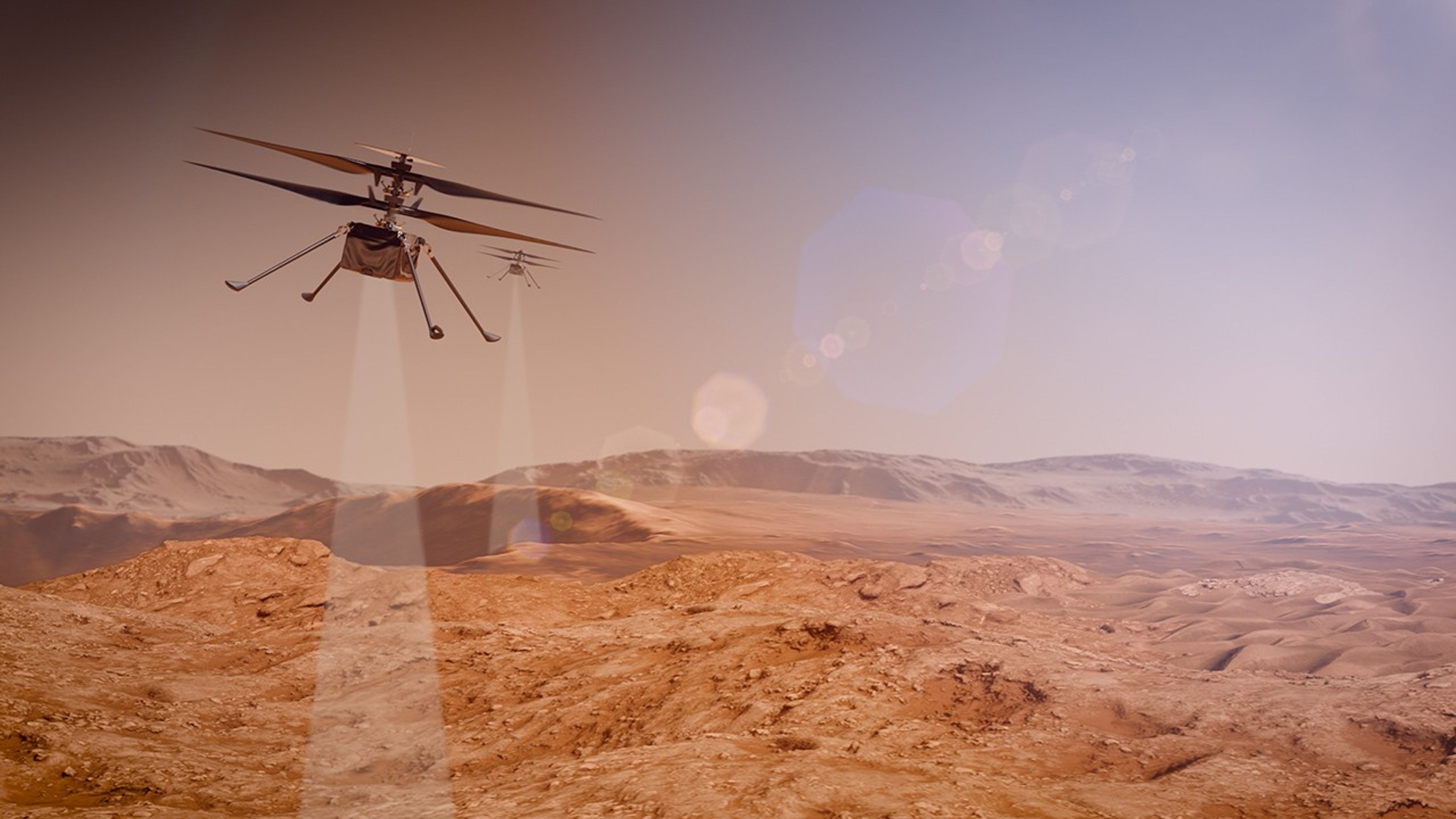 Artist's concept of two SkyFall robotic helicopters flying in tandem over a rugged Martian landscape. In the upper left foreground, the primary helicopter is shown in mid-flight with its dual coaxial rotors spinning, while a second, identical helicopter trails slightly behind it in the distance. Both spacecraft are projecting pale, translucent, cone-shaped sensor beams downward, representing scans with their their ground penetrating radar on the reddish-brown rocky ridges and sandy dunes below. The background features distant crater rims and mountains under a hazy, pale orange sky, accented by a prominent diagonal string of hexagonal pink and purple lens flares.