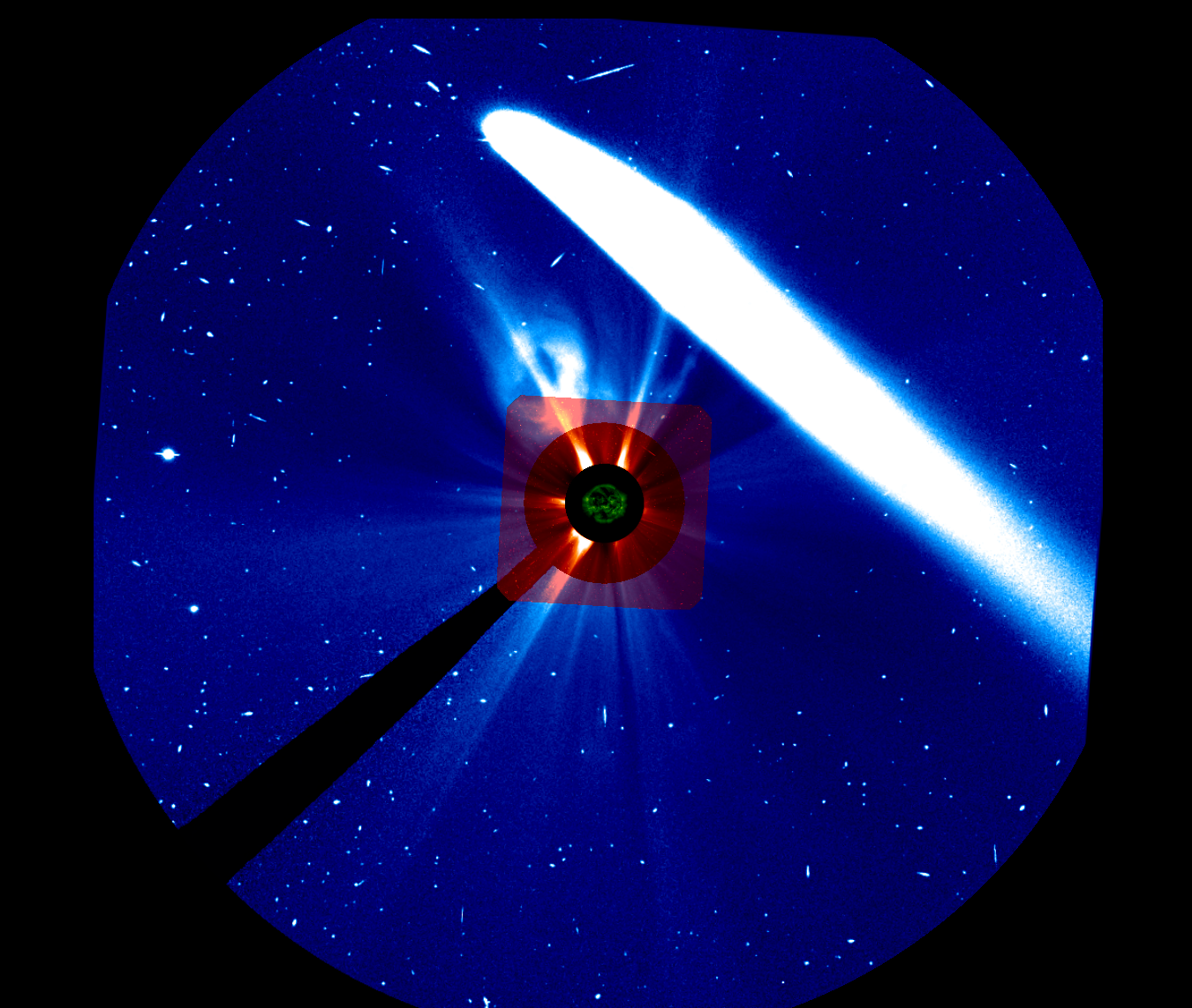 A large, bright white comet tail streaks across a starry, blue-colored background from the top to the lower right. At the very center of the composite image is a green-colored Sun. Around the Sun is a black ring. Around that is a concentric red ring that is framed by a larger, fainter red square. Starting in the red ring and extending out into the red box and the blue surrounding background are white streamers stretching away from the Sun. A white cloud of material appears in the red box and blue background to the upper left of the Sun, below the comet.