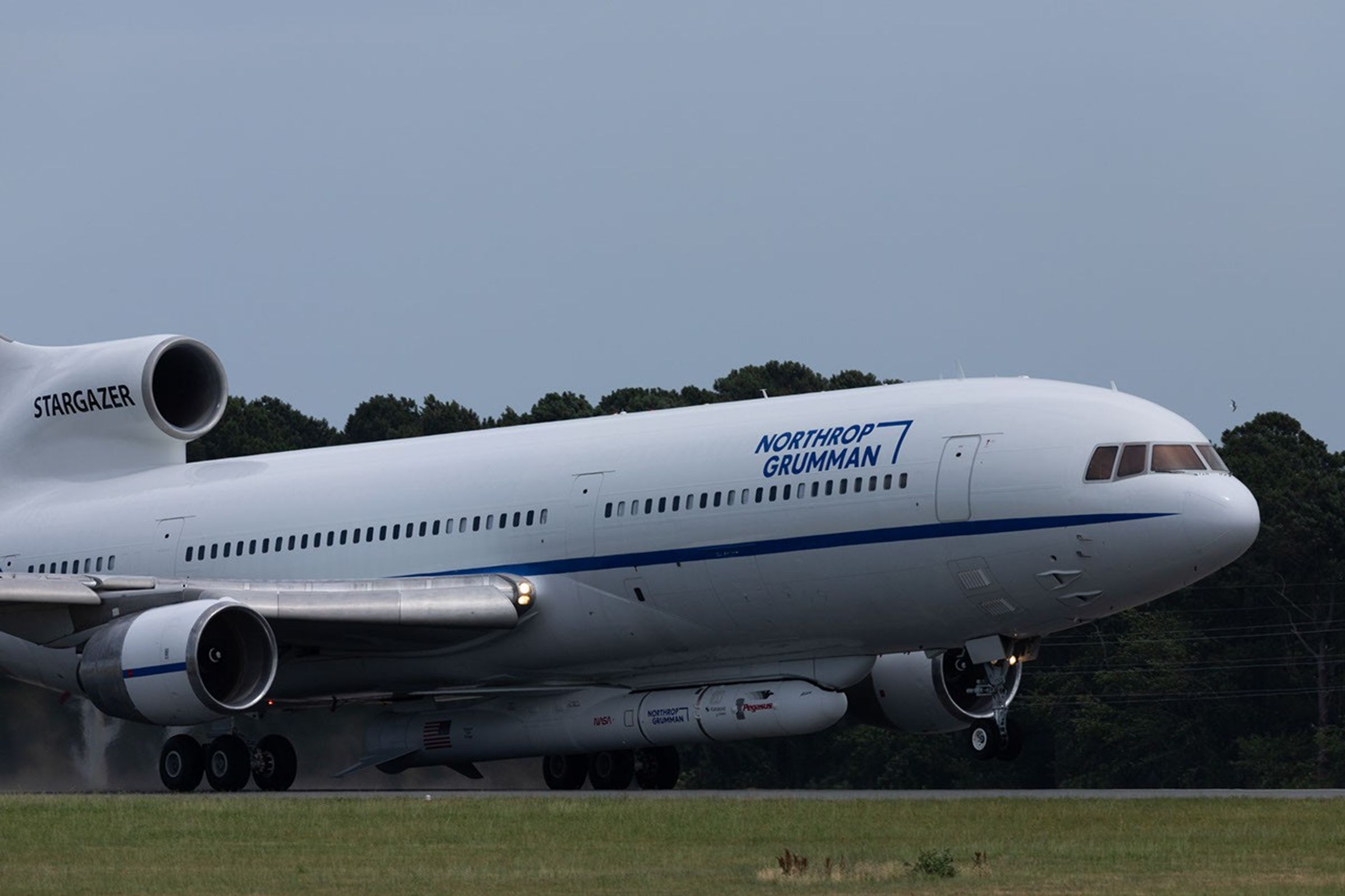 A plane taxiing with a rocket attached to the fuselage