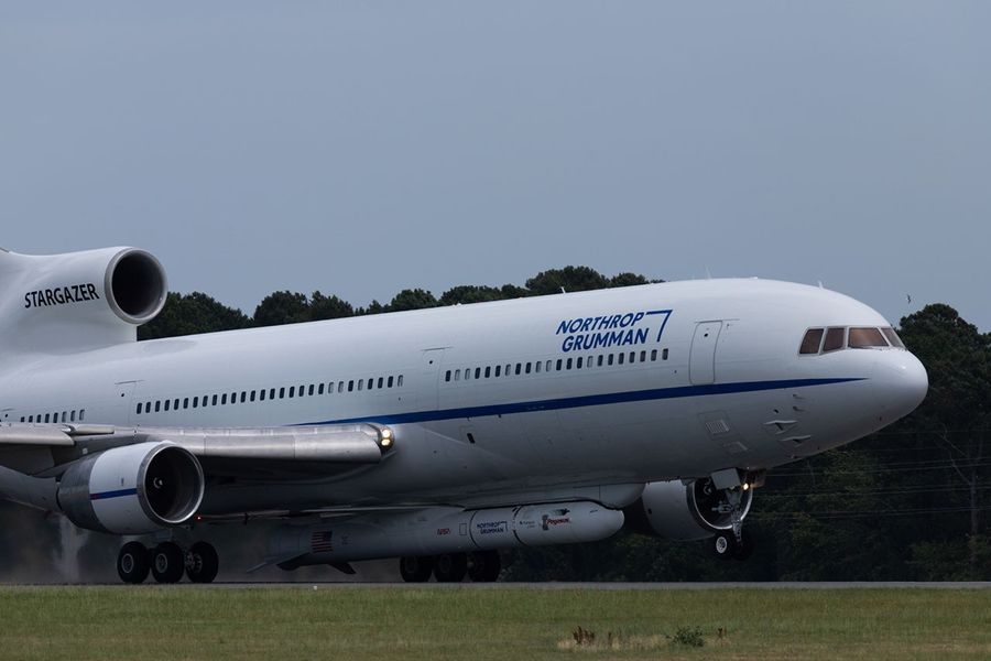 A plane taxiing with a rocket attached to the fuselage