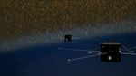 Two black satelittes over a dark blue background that represents Earth's atmosphere. Yellow lines are streaking around the satellites, representing solar wind entering Earth's atmosphere.