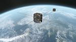 An artist's concept showing TRACERS above Earth. TRACERS is twin satellites, both gray and octagonal, with four poles sticking outward horizontally.