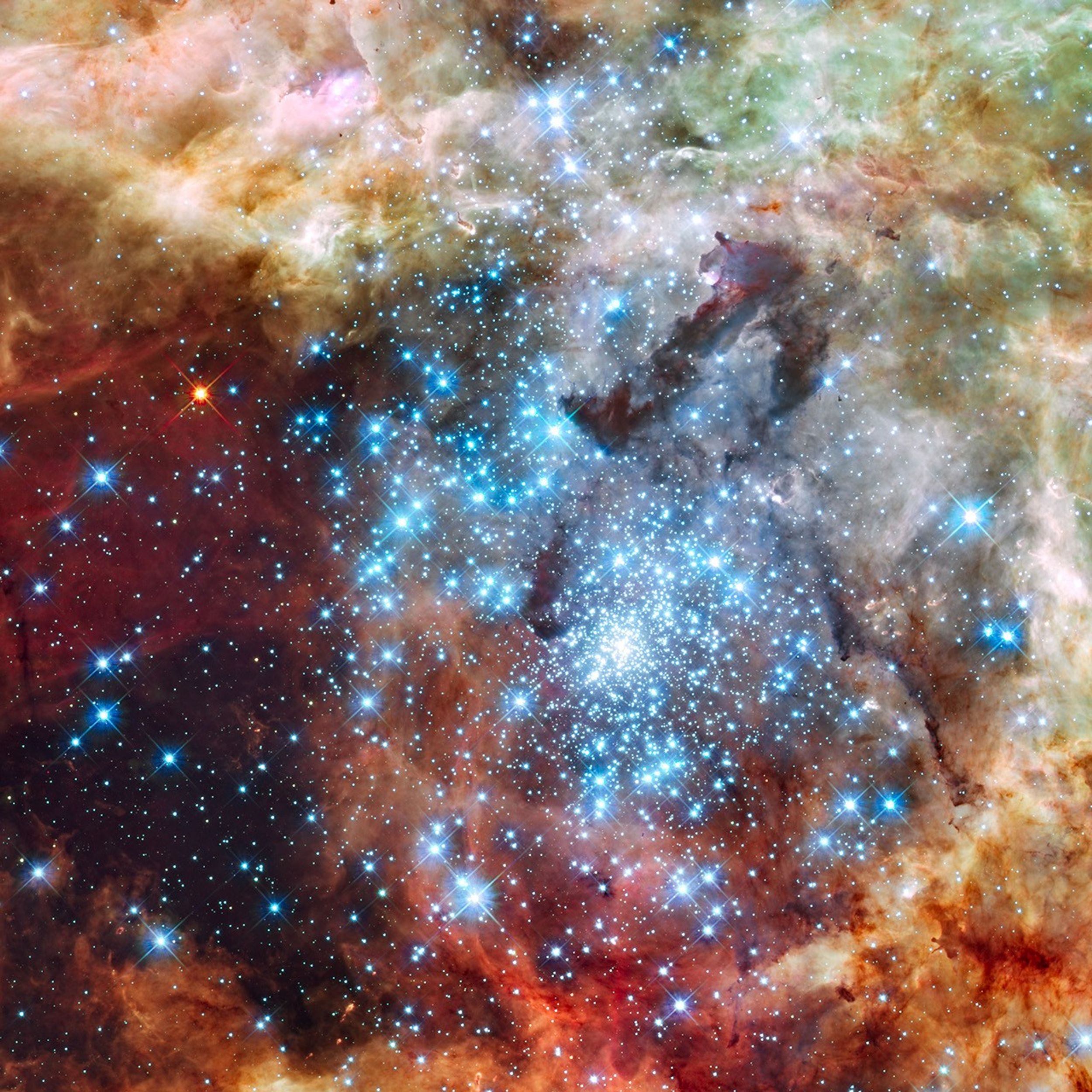 A dense cluster of bright blue-white stars surrounded by fluffy orange and brown material.