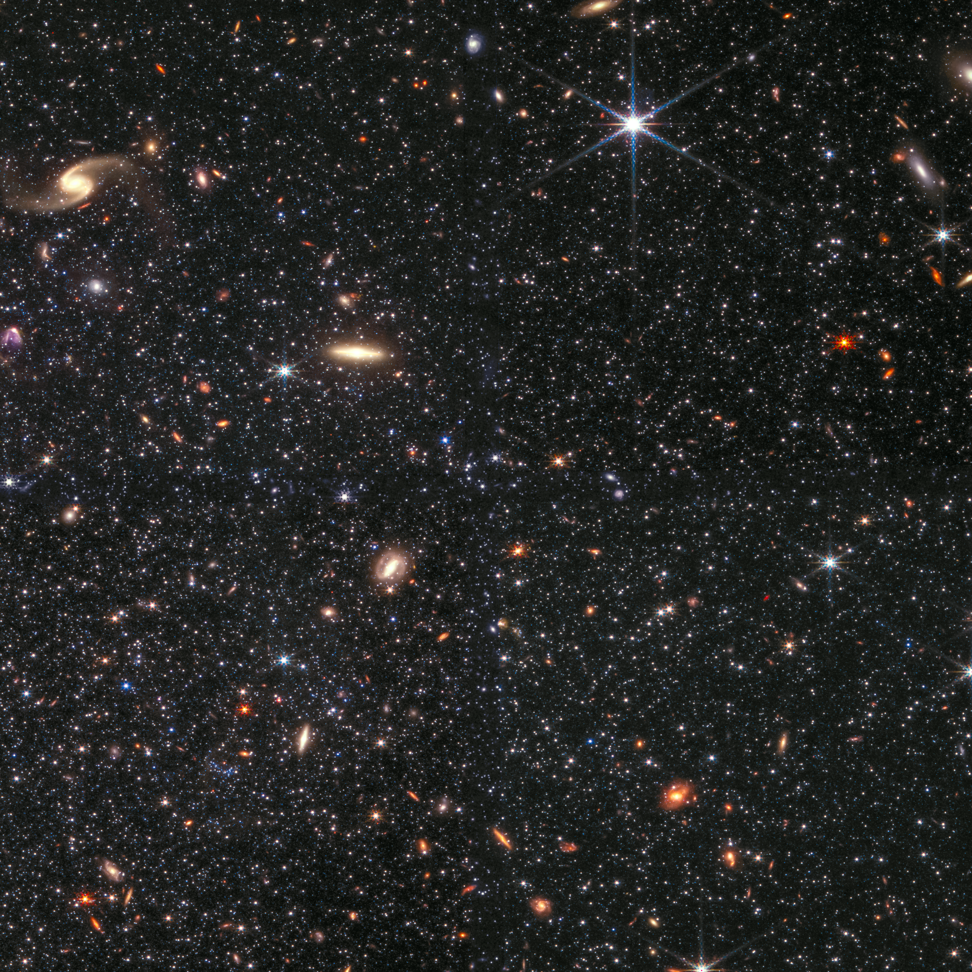 Image showing thousands of clearly differentiated objects (stars and background galaxies) of various color, size, shape, and brightness.