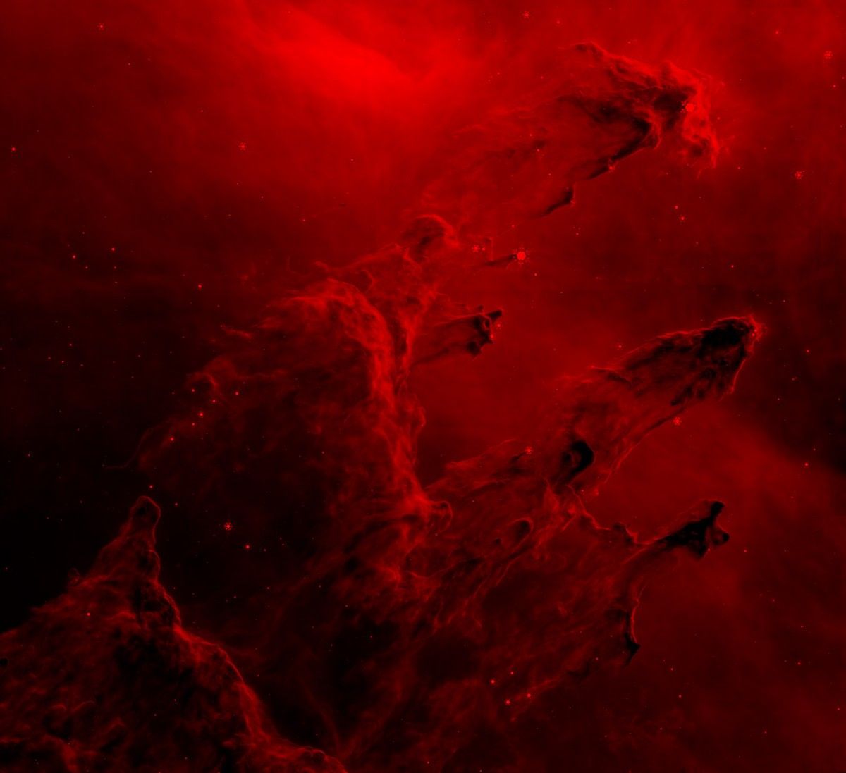 The Pillars of Creation are shown in red. There are bright areas in the finger-like pillars along with dark regions. The left side of the image is a far darker red.