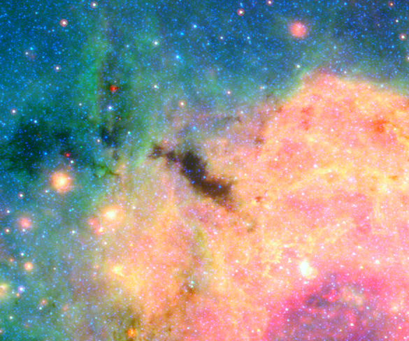 A section of our Milky Way galaxy's center as seen by the Spitzer Space Telescope. Many white points of light are spread across a colorful background.