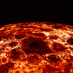Tight view of Jupiter’s north pole shown in shades of dark red to bright white, featuring a large central cyclone encircled by eight cyclones.
