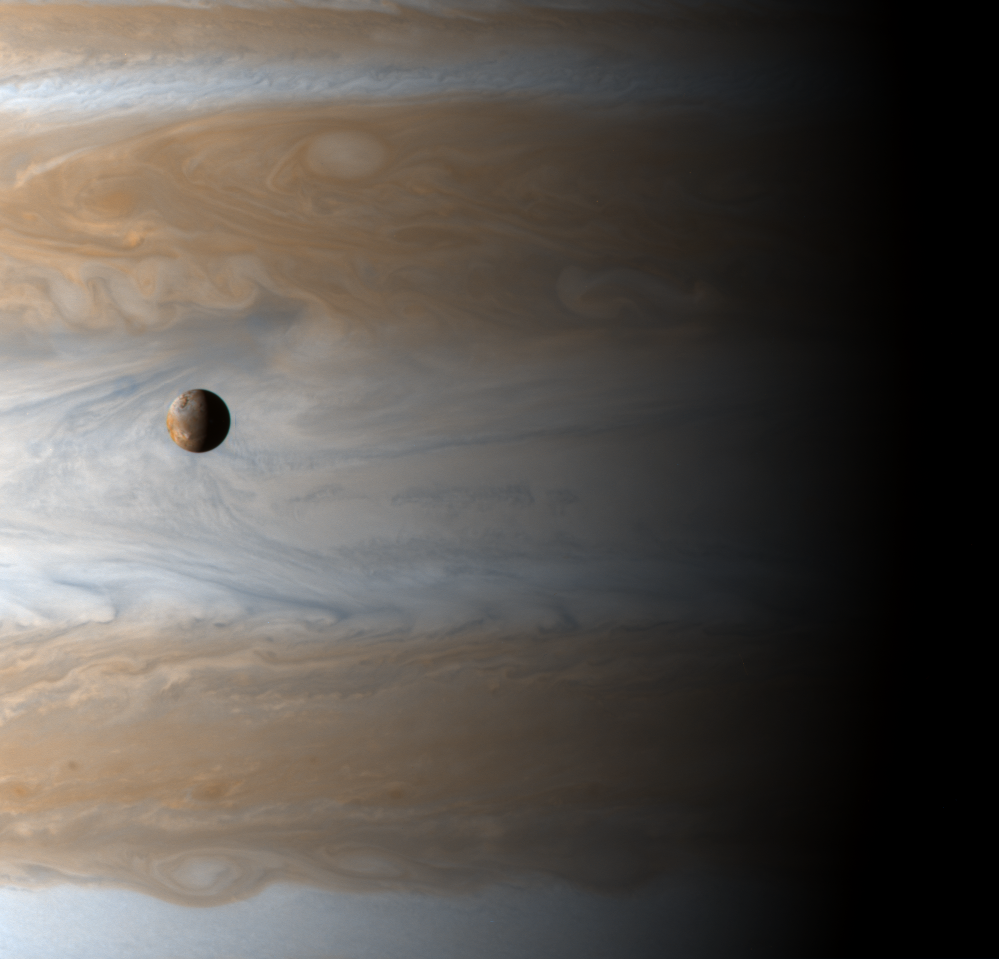 Spacecraft image of a small moon in front of a large planet